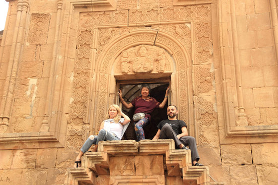 Three of the group posing in the deep carved stone doorway of an Armenian church