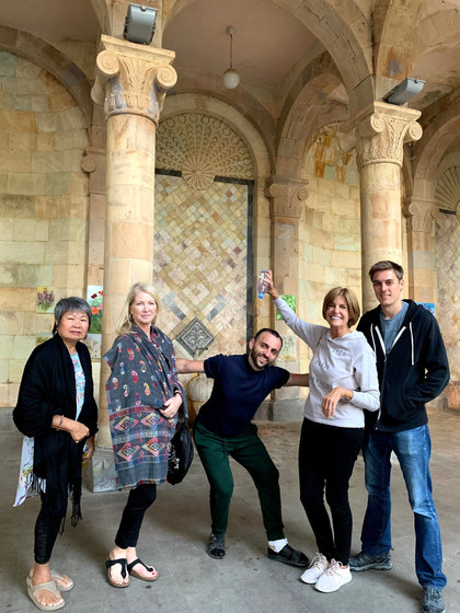 Five of the group under the arcade of a church, in front of a mosaic-tiled doorway