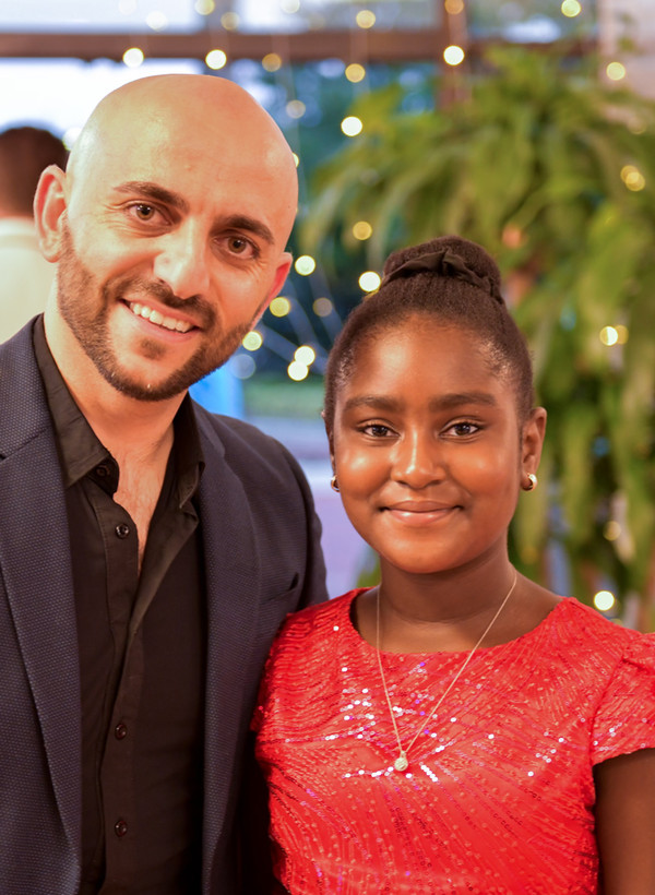 An instructor and a young student smiling together at a VM Ballroom Dance Studios guest party