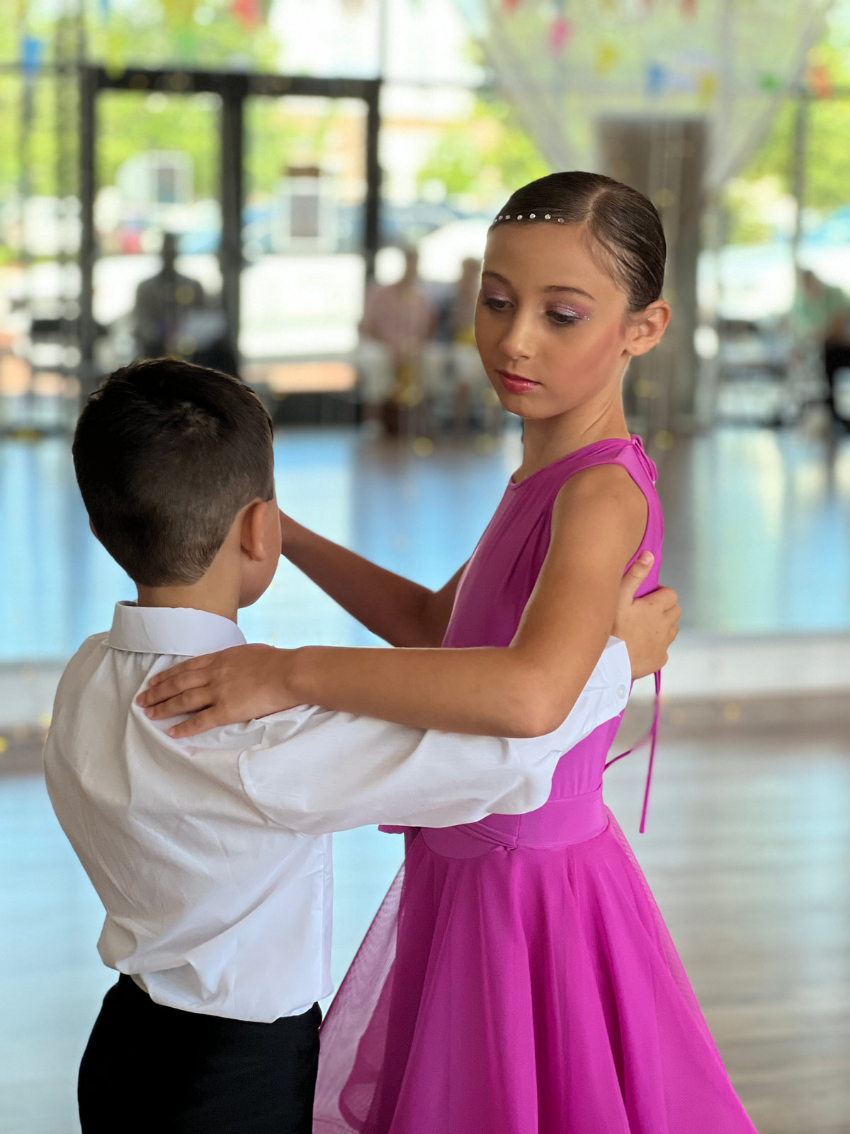 Two young students in a closed ballroom hold on the floor at VM Ballroom Dance Studios