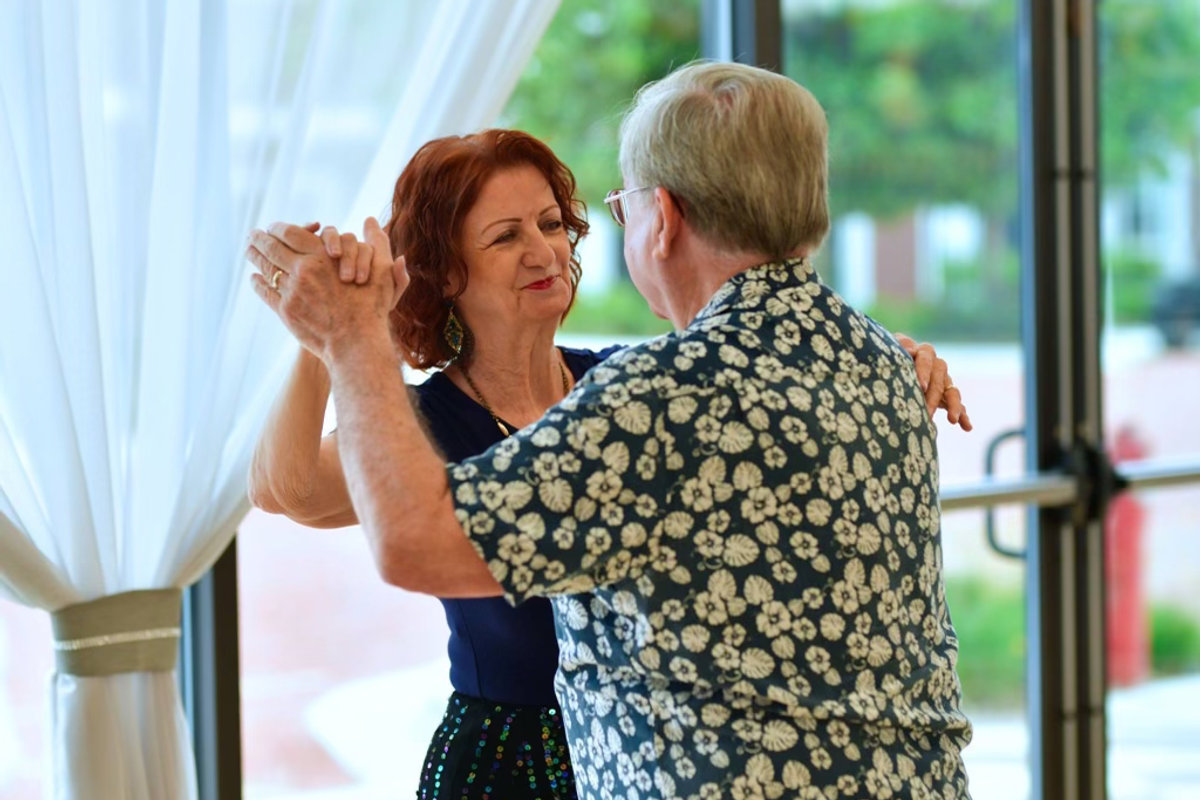Two dancers in closed hold on the studio floor at VM Ballroom Dance Studios