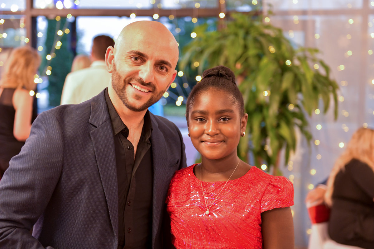 An instructor and a young student smiling together at a VM Ballroom Dance Studios guest party