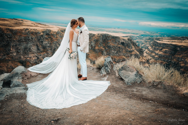 A bride in a white gown and her groom dancing their first dance together